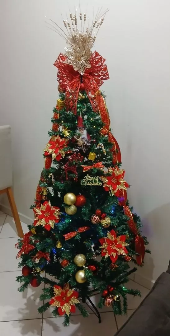 Árvore com flores vermelhas e douradas e iluminação colorida
